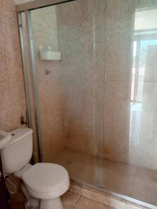 a bathroom with a toilet and a glass shower at Tu escapada en Chichiriviche Venezuela in Chichiriviche