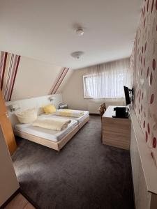 a bedroom with a large bed and a desk at Gasthof Hirschkeller in Göppingen