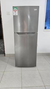 a stainless steel refrigerator sitting on a tile floor at Star Beach Paradise in Kilifi