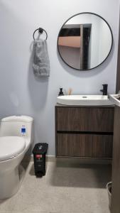 a bathroom with a toilet and a mirror on the wall at Casa 1982 in Manizales