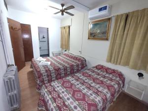 a hotel room with two beds and a ceiling fan at Hotel Viñas San Rafael in San Rafael