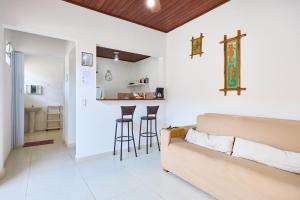 Una sala de estar con un sofá y un bar. en Casinha da Enseada, en Ubatuba