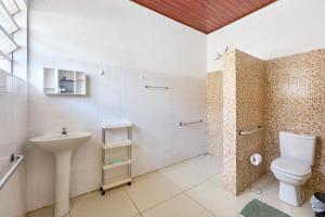 a bathroom with a sink and a toilet and a shower at Casinha da Enseada in Ubatuba +25 photos