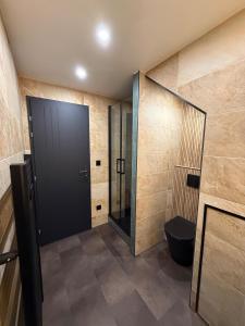 a bathroom with a black door and a toilet at Le RC in Bagnols-les-Bains
