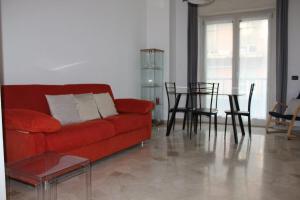 a living room with a red couch and a table at Staurenghi34apartmenT in Varese +15 photos