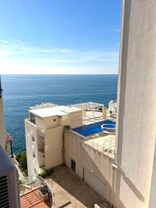 a view of the ocean from the balcony of a building at Modern Seaview Apartment with a Pool in Dobra Voda