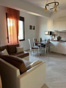 a living room and kitchen with a couch and a table at Modern Seaview Apartment with a Pool in Dobra Voda