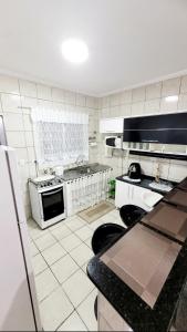 a kitchen with a stove and a counter top at Sobrado em Condomínio Praia das Astúrias in Guarujá