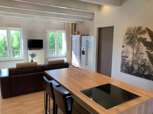 a kitchen and living room with a table and a couch at La Croix-Valmer, La ferme, Le Vergeron, entre terre et mer in La Croix-Valmer