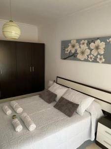 Un dormitorio con una gran cama blanca con almohadas. en SUEÑOS DEL MAR, en Motril