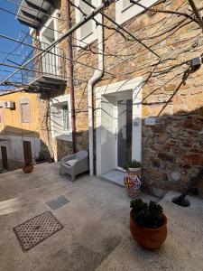 a brick building with a white door and a chair at La Casa di Nonna Maria in SantʼAmbrogio