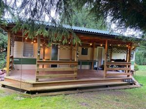 a house with a large wooden deck in the yard at Winiec Dutch Cottage in Winiec