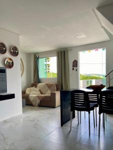 a living room with a couch and a table and chairs at Excelente Flat no alto de Bezerros in Bezerros +9 photos