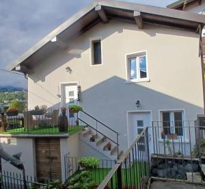 a white house with stairs and a balcony at Lucia's Wood House in Intra
