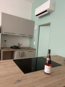 a bottle of wine sitting on a table in a kitchen at Le Cœur de Tournon - Climatisé in Tournon-sur-Rhône +2 photos