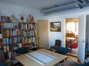 a room with a table and bookshelves filled with books at Vuotson Maja B&B in Vuotso