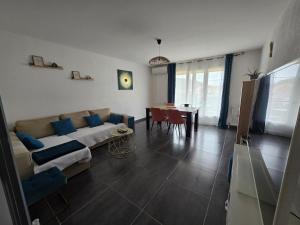 a living room with a couch and a table at Appartement climatisé 4 personnes in Sisteron