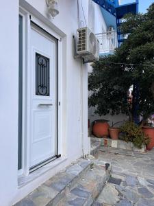 a white door with a window and a fan at Sufiko Studios - Drosia in Armenistis