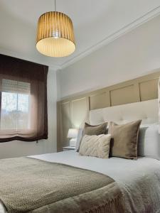 a bedroom with a large bed and a pendant light at Marvera in Caldas de Reis