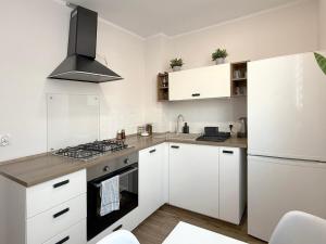 a kitchen with white cabinets and a stove top oven at Szewska, HARLEM APART in Wrocław