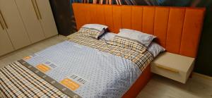 a bed with an orange headboard in a room at M&EA apartments in Târgu-Mureş