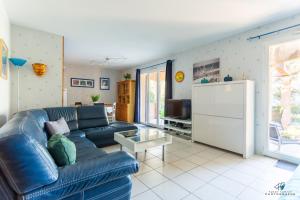 a living room with a blue couch and a table at La Terrasse d'Azur - Vue sur la mer in Lapalme