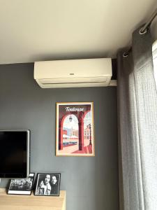 a room with a ceiling fan and a picture on a wall at Le St Aubin appartement Hypercentre de Toulouse in Toulouse