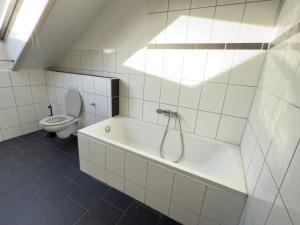 a white bathroom with a tub and a toilet at Easy Stay Leverkusen in Leverkusen +27 photos