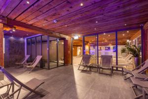 a room with chairs and tables and a wooden ceiling at Naco Aparthotel by Arca Spa in Zermatt +84 photos