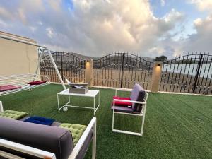 eine Terrasse mit Sofa und Stühlen und einer Schaukel in der Unterkunft سحاب تهلل السودة Sahab AL-Sodah in Sawdāʼ