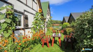 a garden with a table and chairs and flowers at Skrawek Nieba in Dąbki +4 photos