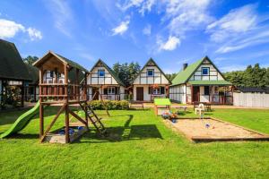 a yard with a playground in front of a house at Skrawek Nieba in Dąbki