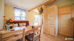 a dining room with a table and chairs and a door at Skrawek Nieba in Dąbki