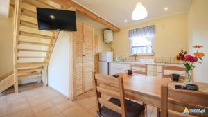 a kitchen with a dining room table and a television at Skrawek Nieba in Dąbki