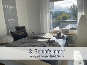 a bedroom with a bed and a window at PENTHOUSE - 3 Schlafzimmer- sonnige Dachterrasse -Whirlpool & Alpenblick - Perfekt für Romantik oder Familienurlaub mit Kind, Hund willkommen - by FerienWohnenAmSee - in Überlingen