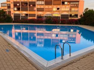 an empty swimming pool in front of a building at Absolu chic naturiste in Cap d'Agde