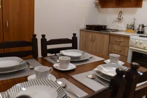a table with plates and utensils on it in a kitchen at Cozy Garden Villa in Prizren in Prizren +13 photos
