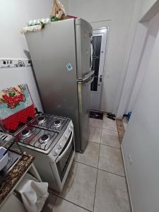 a kitchen with a stove and a refrigerator at Um quarto com banheiro privativo in Sao Paulo