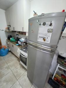 a kitchen with a stainless steel refrigerator at Um quarto com banheiro privativo in Sao Paulo