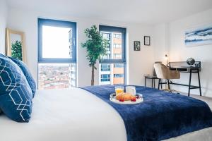 a bedroom with a bed with a tray of food on it at Penthouse Haven - Gants Hill - 2 Bedroom Flat in Redbridge