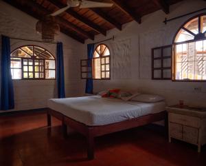 a bedroom with a bed in a room with two windows at Big Surf House in Popoyo