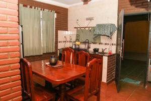a kitchen with a wooden table with chairs and a sink at Departamentos Termas tu Segundo Hogar in Termas de Río Hondo