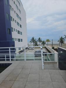 a hotel balcony with a view of the beach and a building at Apartamento para aproveitar a praia in Praia Grande