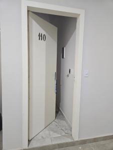 a hallway with a white door with the number at Apartamento para aproveitar a praia in Praia Grande