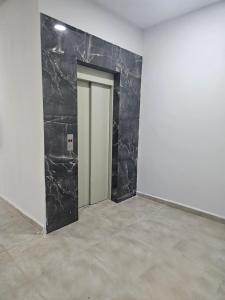 a room with a black marble wall and a door at Apartamento para aproveitar a praia in Praia Grande +17 photos