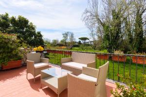a patio with chairs and tables and a fence at Golden Luxe - WoW Forte dei Marmi Terrace Style in Forte dei Marmi