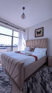 a large bed in a bedroom with a large window at City Pen - By Tito Homes in Nairobi +18 photos