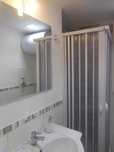 a bathroom with a sink and a shower with a mirror at M&D Appartamenti in Trapani