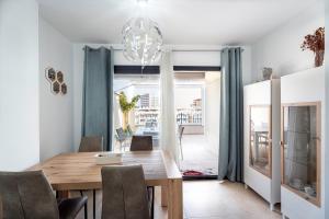 a dining room with a wooden table and chairs at Ático Azucarera Torre del Mar in Torre del Mar