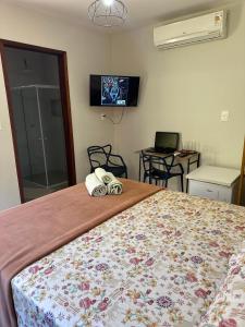 una camera da letto con un letto con copriletto a fiori di Suíte Peixe Espada a Praia do Forte